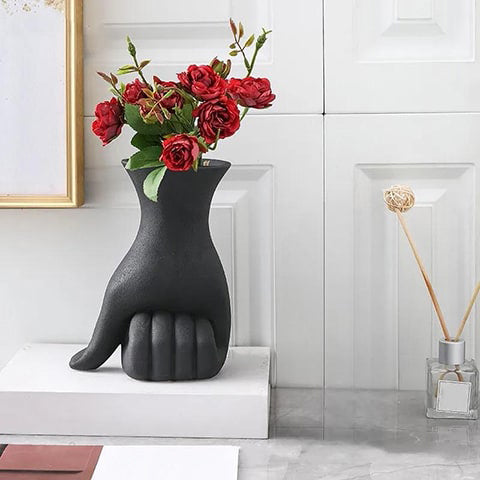Vase design main poing fermé en céramique couleur noir présentation avec bouquets de roses rouges