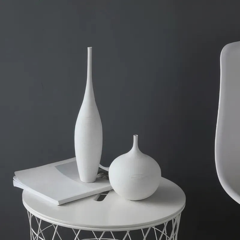 Vase Design Moderne Noir ou Blanc présentation des modèles Blanc grand et blanc petit sans fleurs sur une petite table blanche.