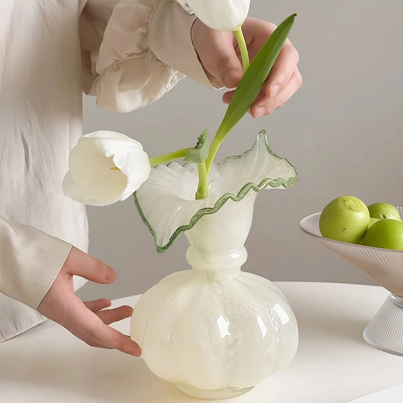 Vase Élégant Rond avec Col Forme Feuille Dentelée, mise en scène du modèle Blanc avec tulipes blanches sur une table blanche.