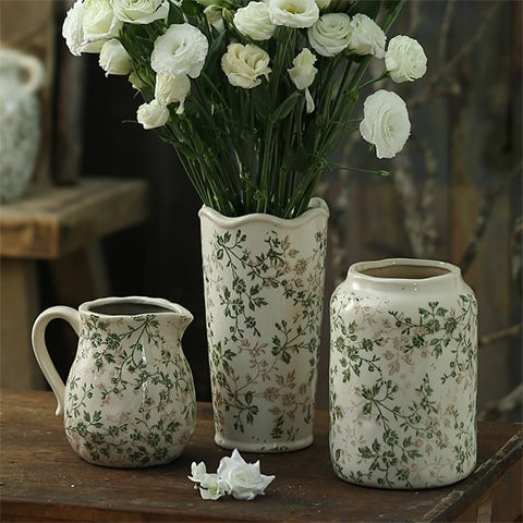 Vase d'époque motif feuillages verts mise en scène des modèles A B et C avec fleurs blanches sur une table en bois ancien