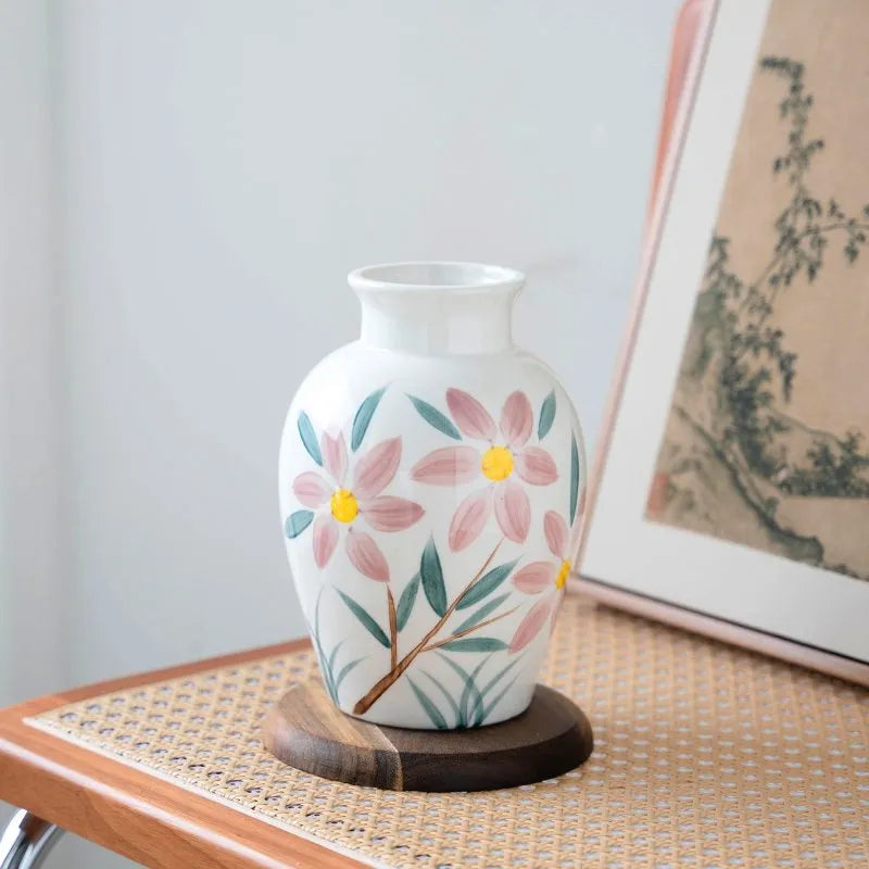 Vase Fantaisie Motif Fleurs Peint à la Main, présentation du modèle A sans fleurs sur un meuble en bois.