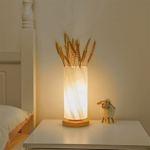 Vase lampe romantique pour fleurs séchées, présentation du modèle rond allumé avec des épis de blés sur table de nuit.