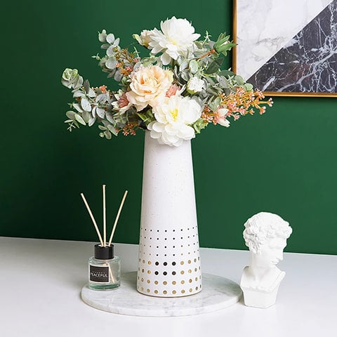 Vase moderne blanc motifs dorés présentation avec bouquet de fleurs