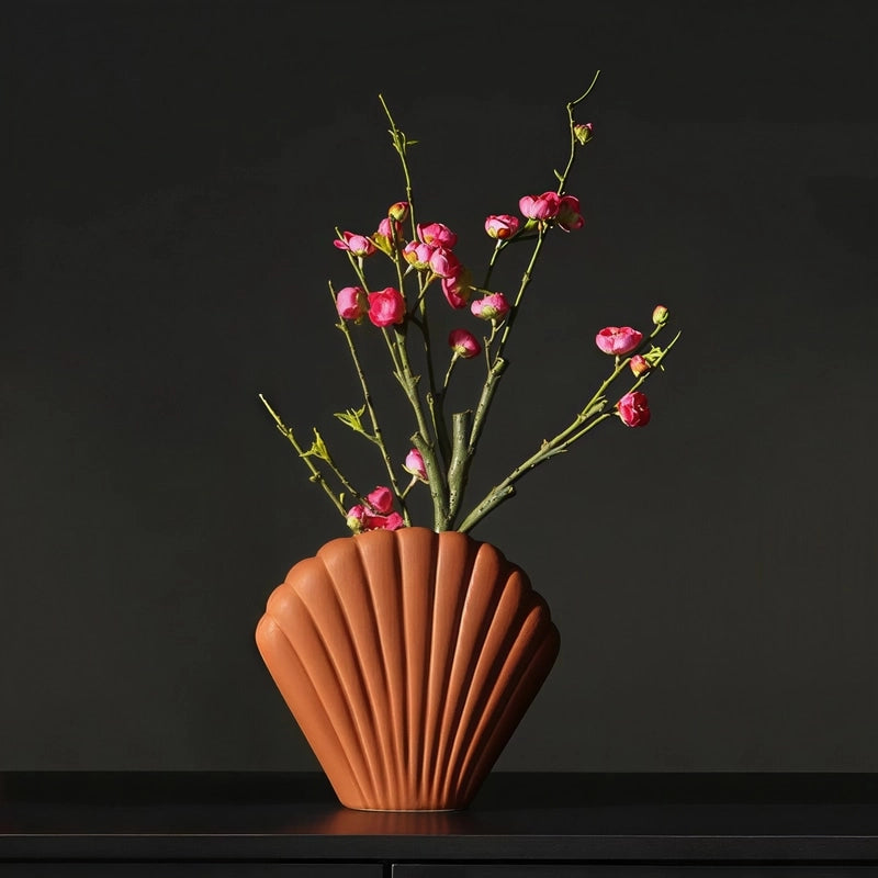 Vase Moderne Coquille Saint-Jacques Couleur marron présentation avec fleurs sur une table noire.