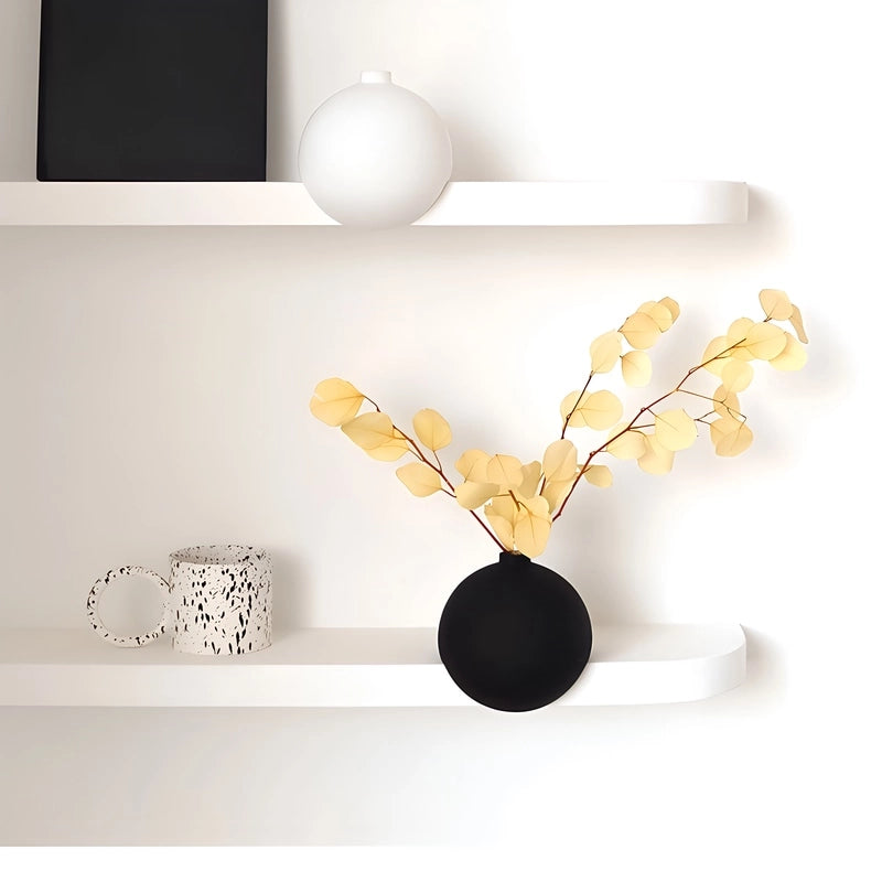 Vase Moderne Sphérique à Angle Droit en Céramique, Blanc sans fleurs et Noir avec fleurs en Céramique, présentation posé sur une étagère.