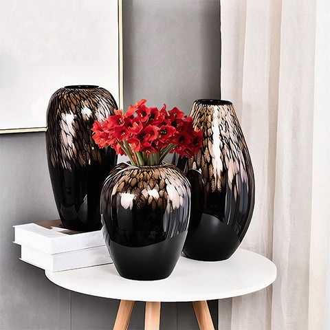 Vase noir pailleté doré en verre présentation de tous les modèles sur une table avec bouquet de fleurs rouges qui orne le modèle A