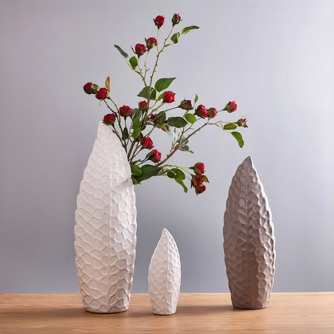 Vase nordique forme de feuille design en céramique présentation de tous les modèles avec tiges florales rouges dans le modèle L blanc