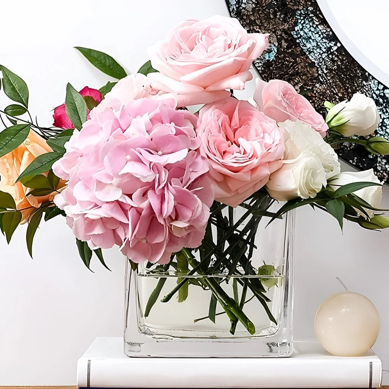 Vase Petit Cube Décoratif Transparent avec bouquet de fleurs sur un meuble.