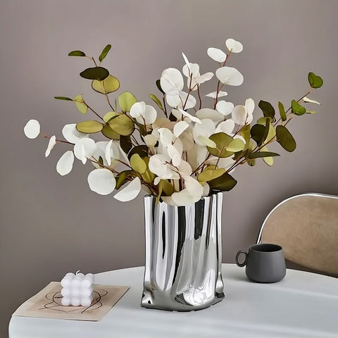 Vase plissé élégant or ou argent en céramique présentation du modèle Argenté avec tiges d'eucalyptus.