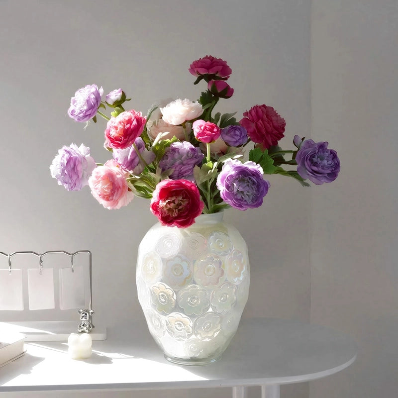 Vase Raffiné Motifs Floraux Reflets Nacrés, présentation avec bouquet de fleurs sur une table blanche.