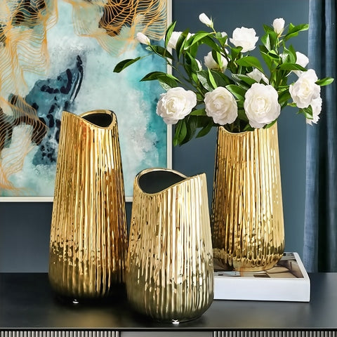 Vase raffiné rayé doré en Céramique présentation de tous les modèles sur une table avec des fleurs blanches.