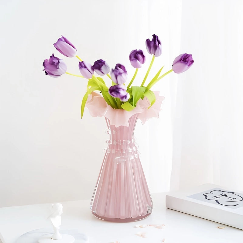 Vase Robe Rose Cintrée Bustier Élégant avec bouquet de tulipes violettes sur une table blanche.
