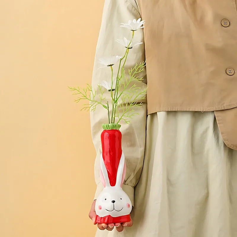 Vase Soliflore Tête de Lapin et Carotte, présentation du modèle rouge avec tige de fleurs, tenu en main.