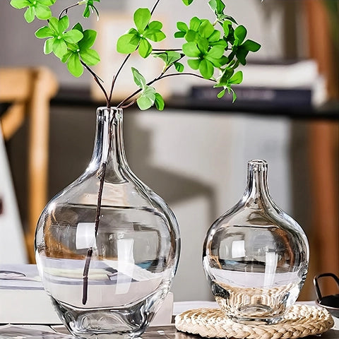 Vase transparent Dame Jeanne en verre, présentation des modèle L et M avec feuillage sur une table.