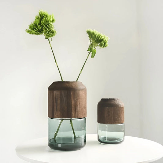 Vase Tubulaire Transparent Bi-Matières présentation des modèles Grand avec tiges florales et Petit sans fleurs sur une table blanche.