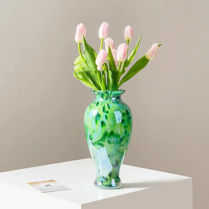 Vase Vert Émeraude Raffiné Motif Abstrait présentation avec bouquet de fleurs sur une table blanche.