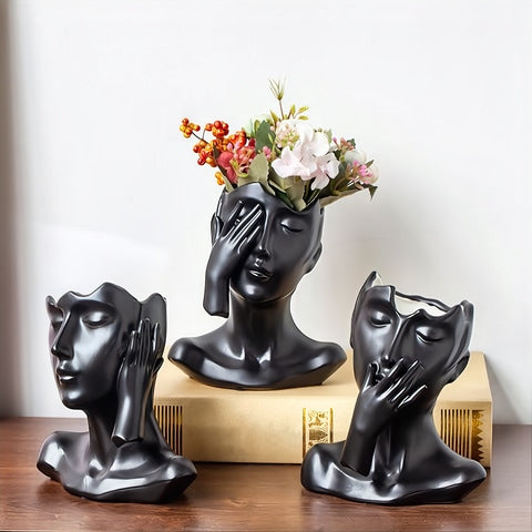 Vase visage femme esthétique en céramique des modèle A, B et C noir avec fleurs sur une table