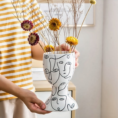 Vase visages abstraits original en céramique tenue en main orné de fleurs séchées