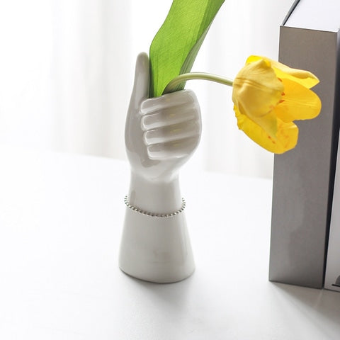 Vase blanc porcelaine main pousse levé en Céramique présentation style A avec tulipe jaune, à côté d'une pile de livres.