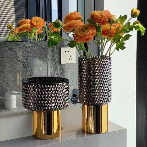 Présentation des modèles A et B avec fleurs orange du vase noir et doré luxueux.